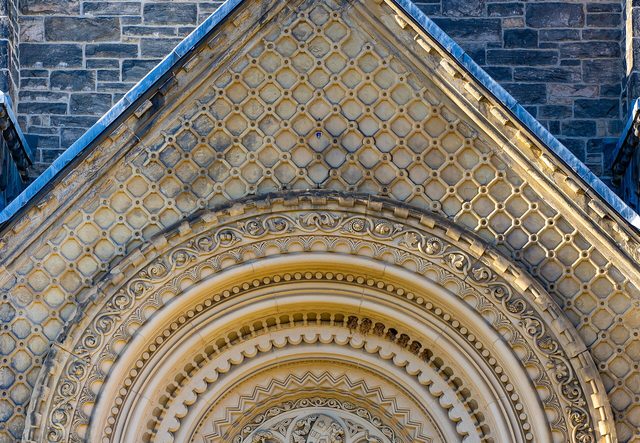 Portal de pedra do University College, na Universidade de Toronto, com portão de ferro trabalhado