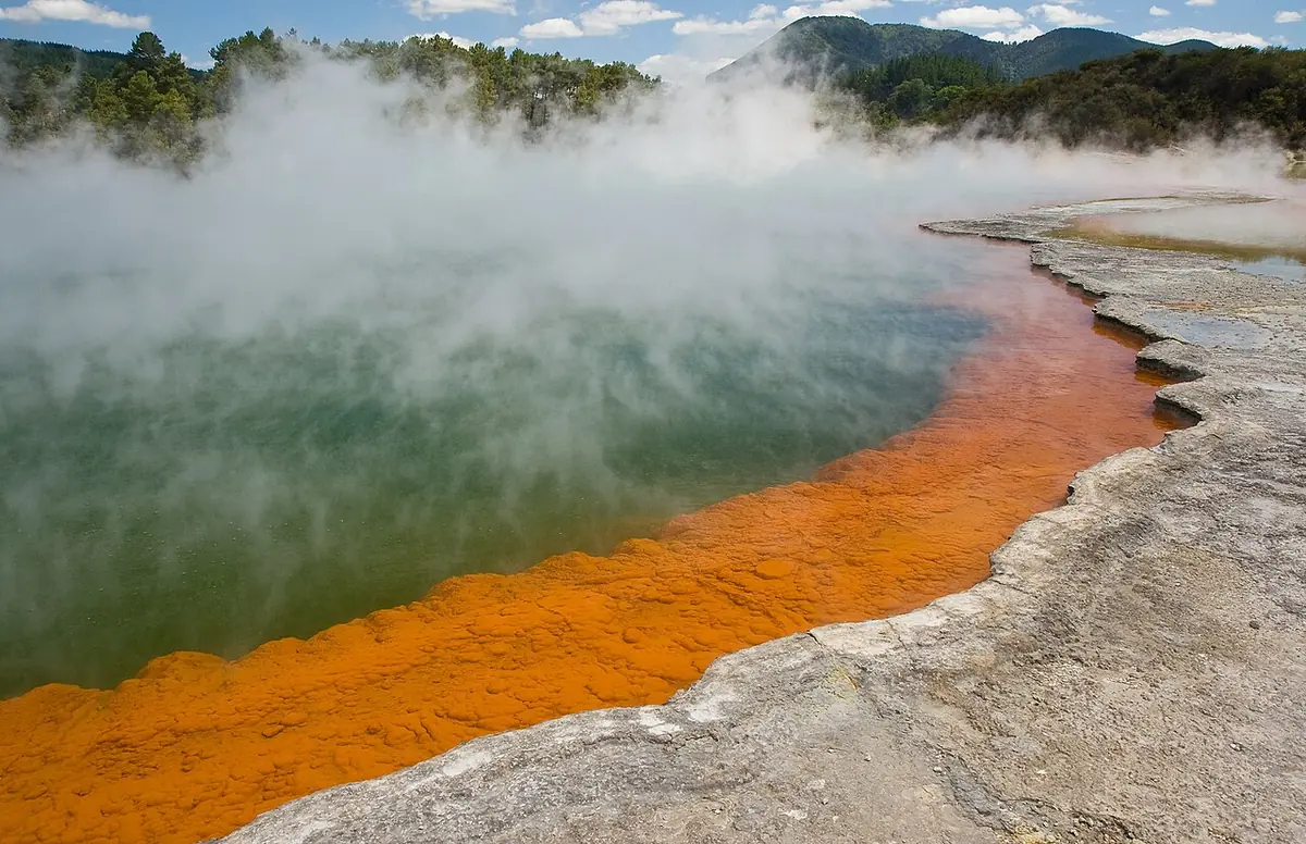 Piscina termal Champagne Pool em Wai-O-Tapu, com água fumegante e borda laranja vibrante