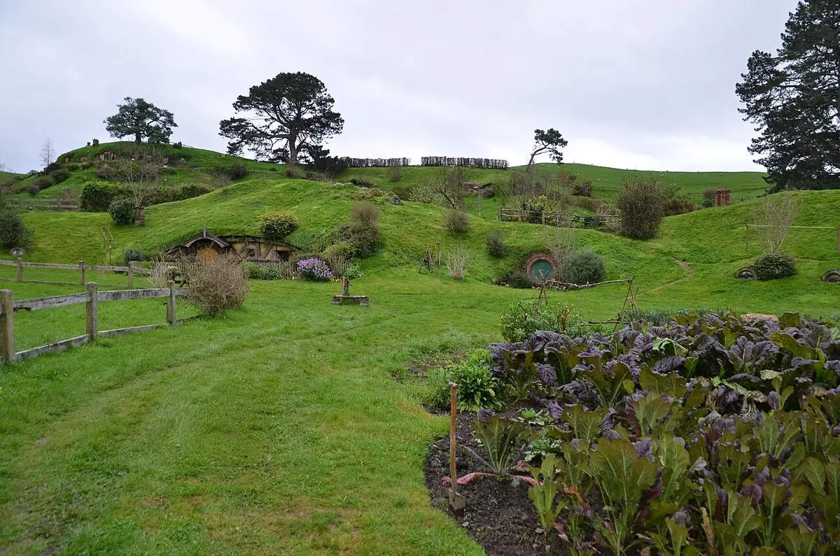 Jardins floridos e portas redondas coloridas das tocas de hobbit no set permanente de Hobbiton