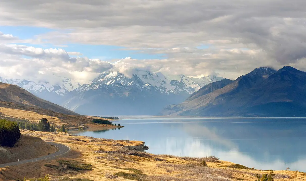 Estrada cênica à beira do Lake Pukaki com o Aoraki Mount Cook nevado ao fundo